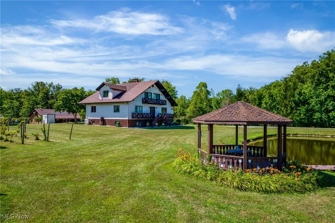 View of green lawn with a gazebo and a water view