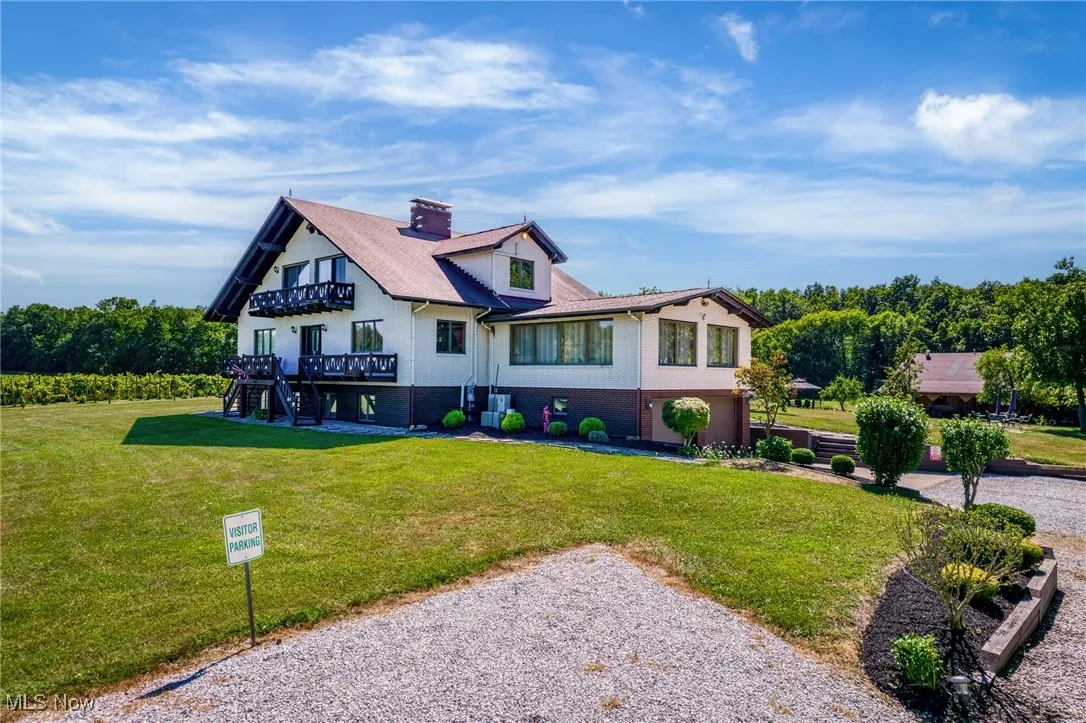 Tudor home featuring stairs, a front lawn, a deck, a chimney, and driveway
