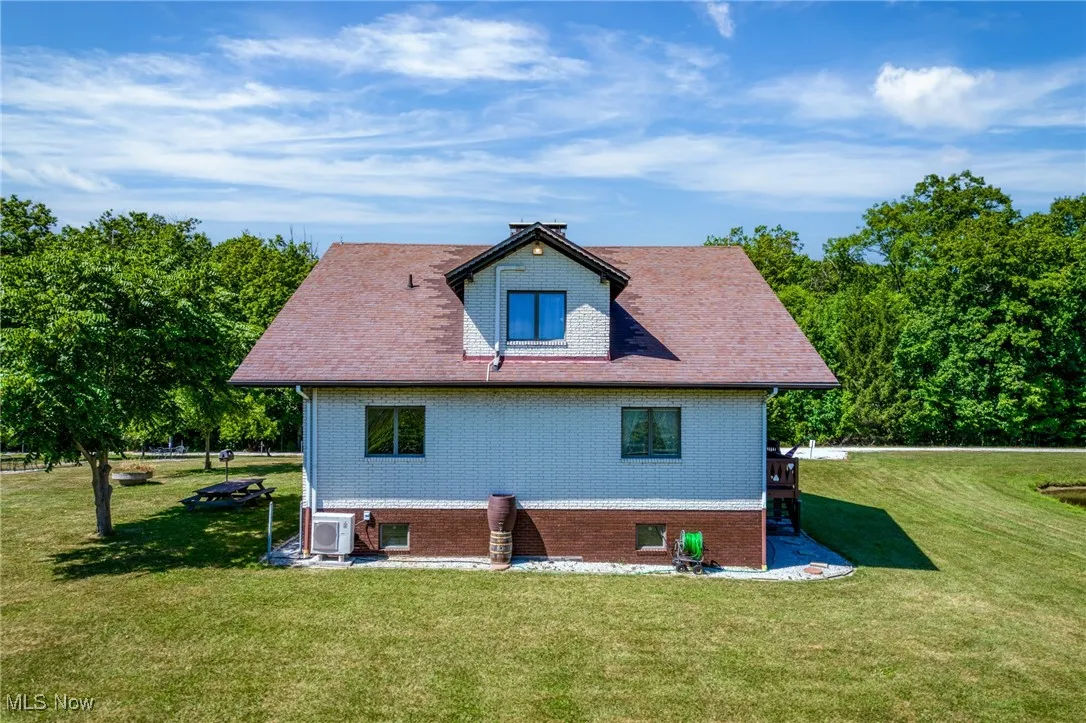 Back of property featuring a yard and brick siding