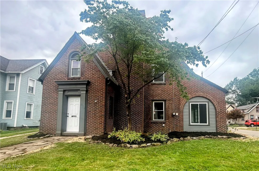 View of front facade with a front lawn and brick siding