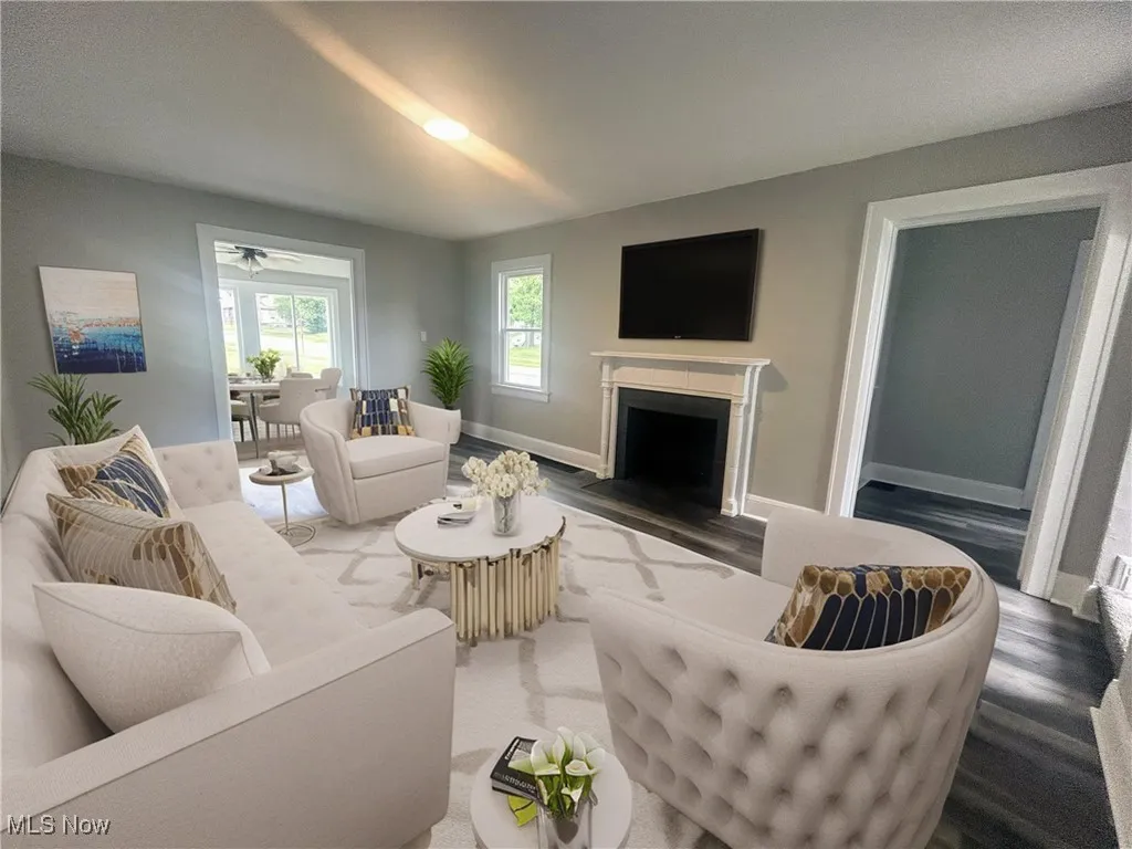 Living room featuring wood finished floors, a fireplace, and ceiling fan