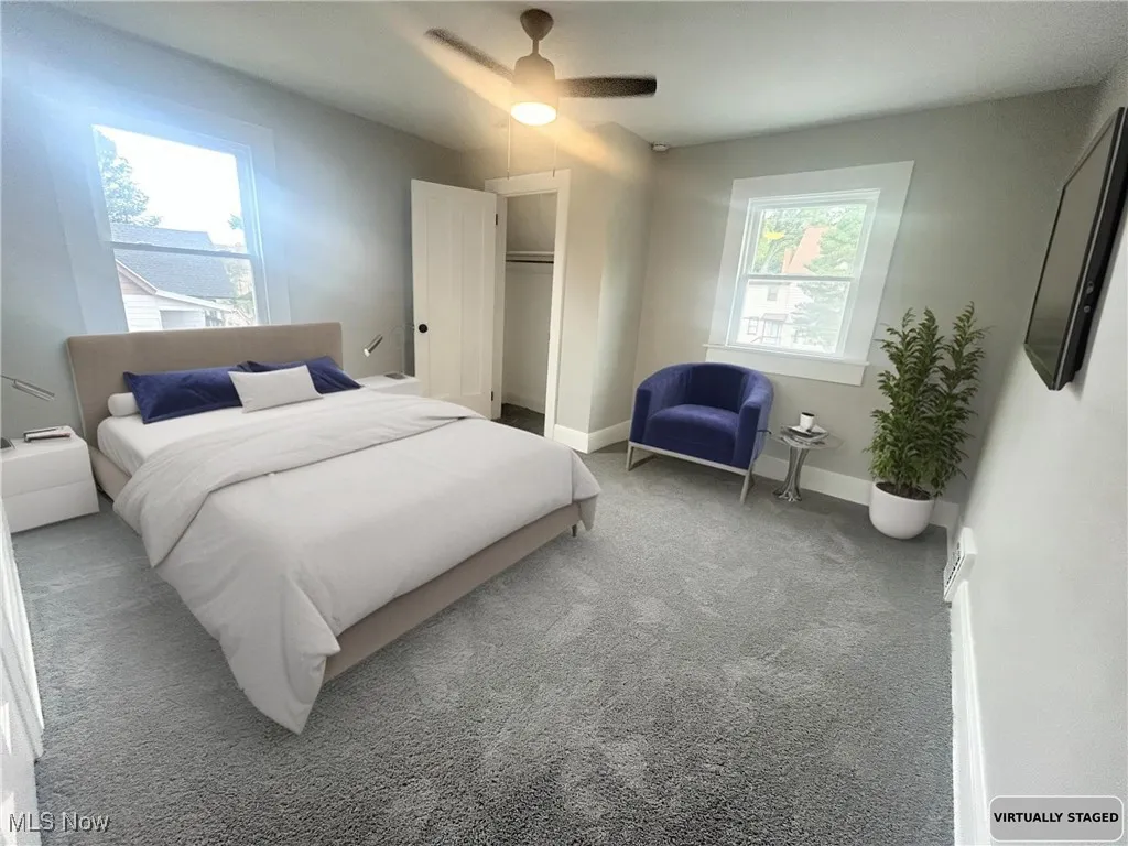 Carpeted bedroom featuring ceiling fan and baseboards