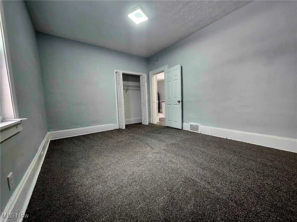 Unfurnished bedroom with carpet and a closet