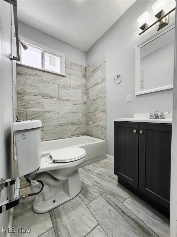 Full bathroom featuring vanity, shower / bathtub combination, and a textured ceiling
