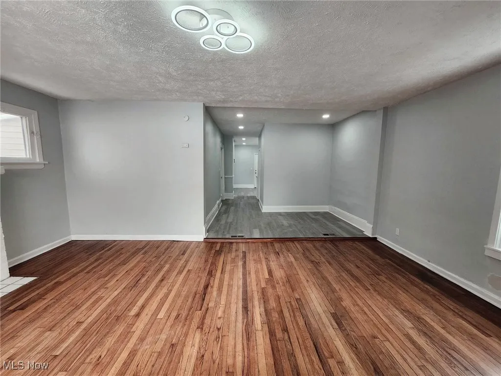 Below grade area featuring dark wood finished floors and a textured ceiling