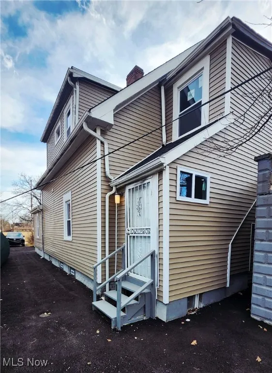 View of home's exterior featuring a chimney and entry steps