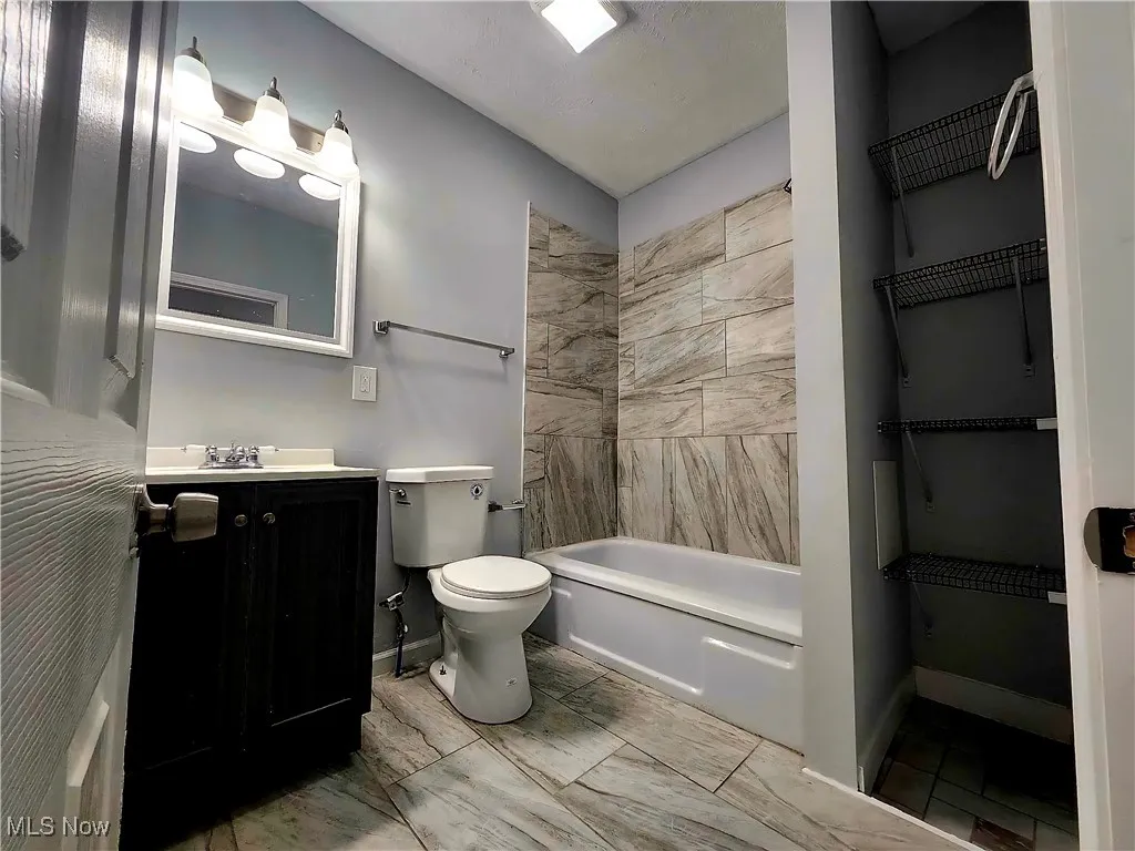 Full bath with vanity and shower / tub combination