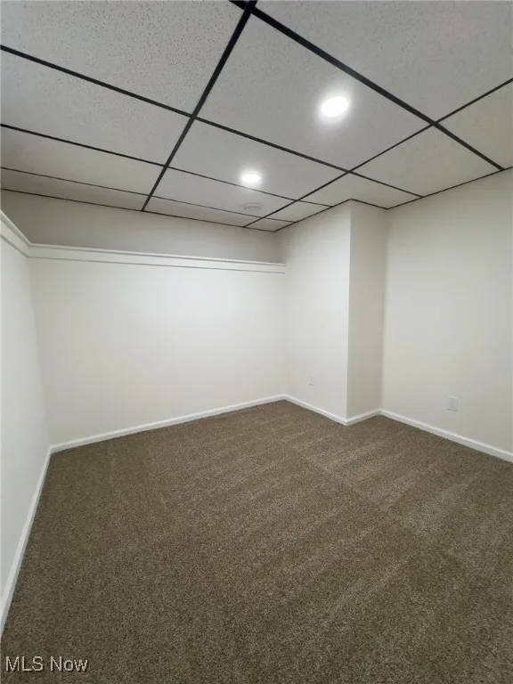 Finished basement with dark carpet, a drop ceiling, and recessed lighting