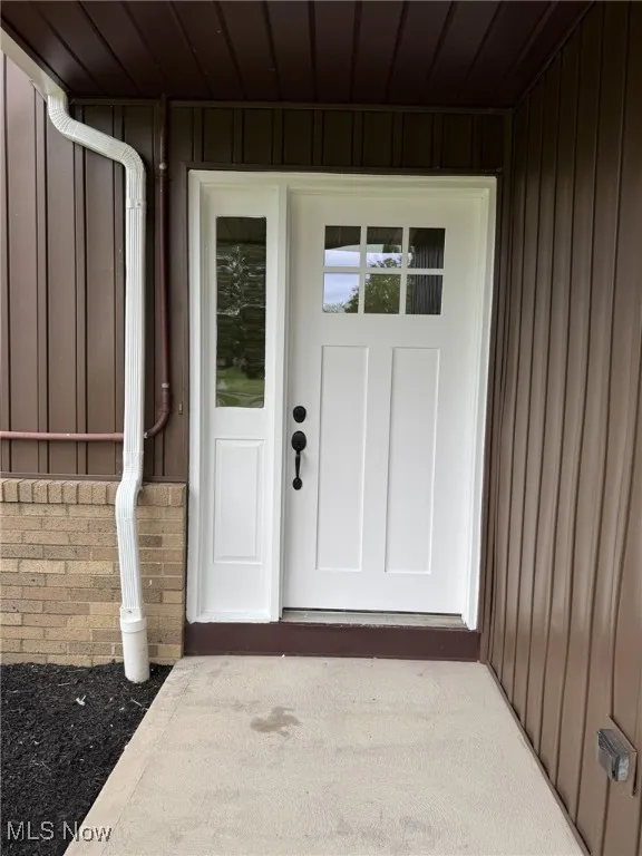 Property entrance featuring board and batten siding