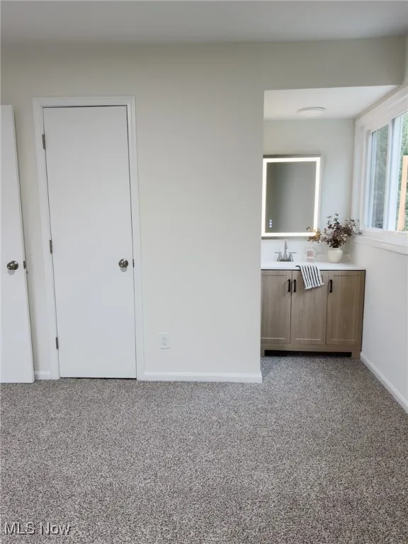 Bedroom with light colored carpet and baseboards