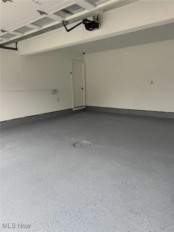 Garage with baseboards and a garage door opener