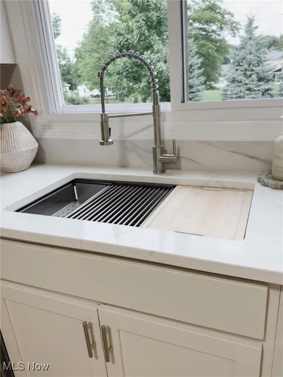 Kitchen view of white cabinets and light stone countertops