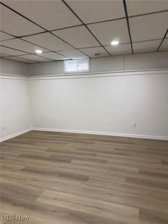 Basement with a paneled ceiling, wood finished floors, and recessed lighting