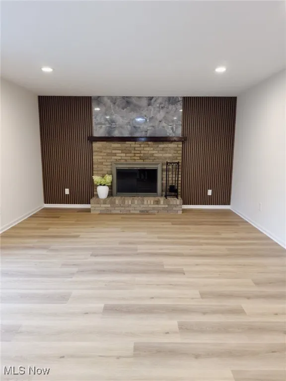 Unfurnished living room featuring a fireplace, light wood-type flooring, and recessed lighting