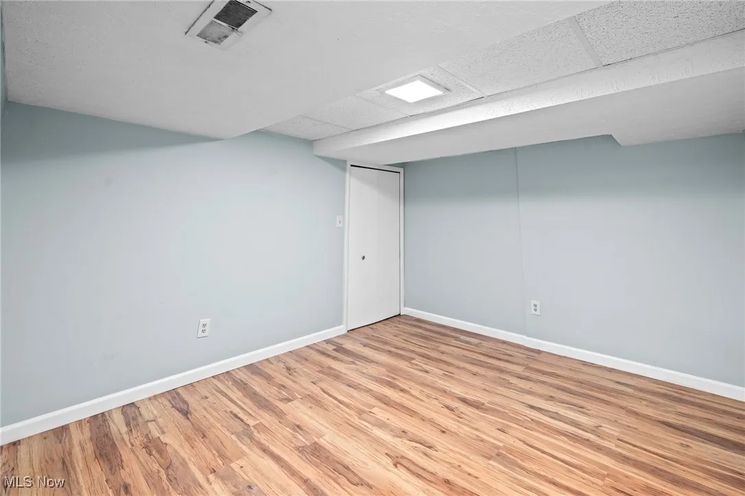 Finished below grade area featuring wood finished floors and a drop ceiling