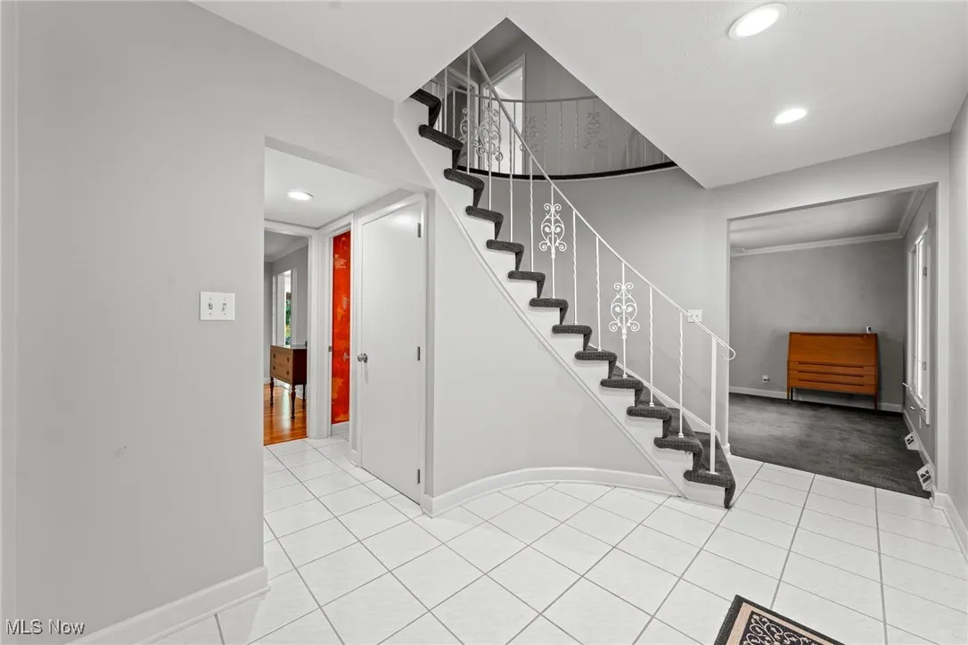 Stairway with recessed lighting and tile patterned flooring