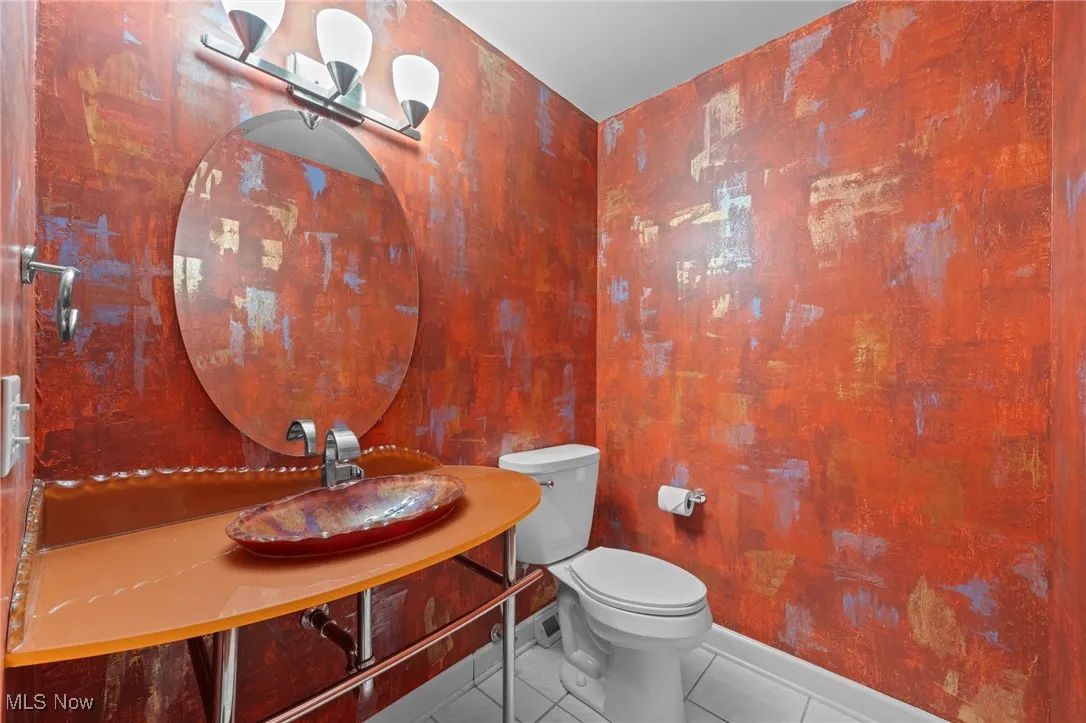 Half bath featuring tile patterned flooring and toilet