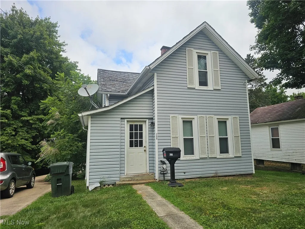 View of front facade with a front lawn and a chimney
