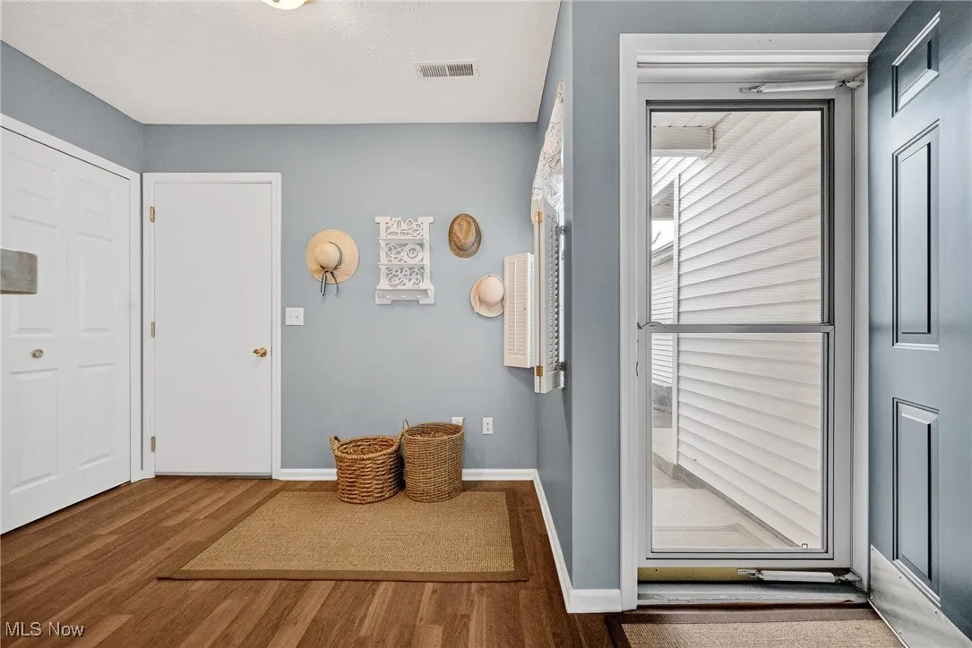 Doorway featuring baseboards and wood finished floors