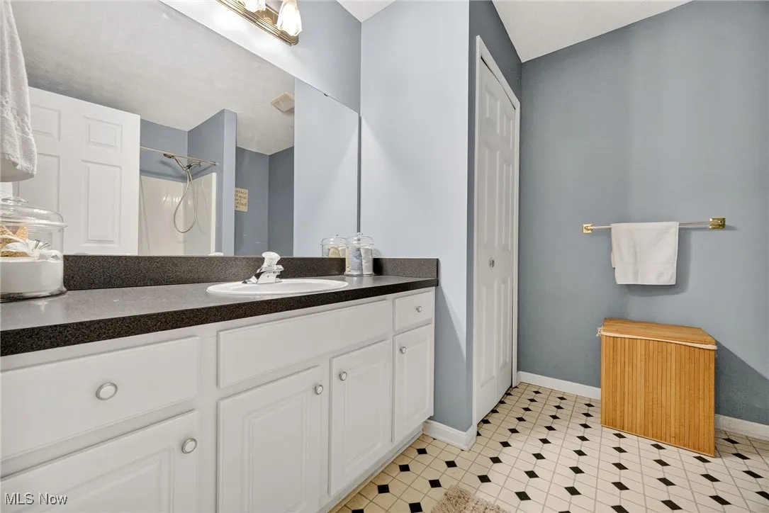 Full bathroom with vanity, a shower, and a closet