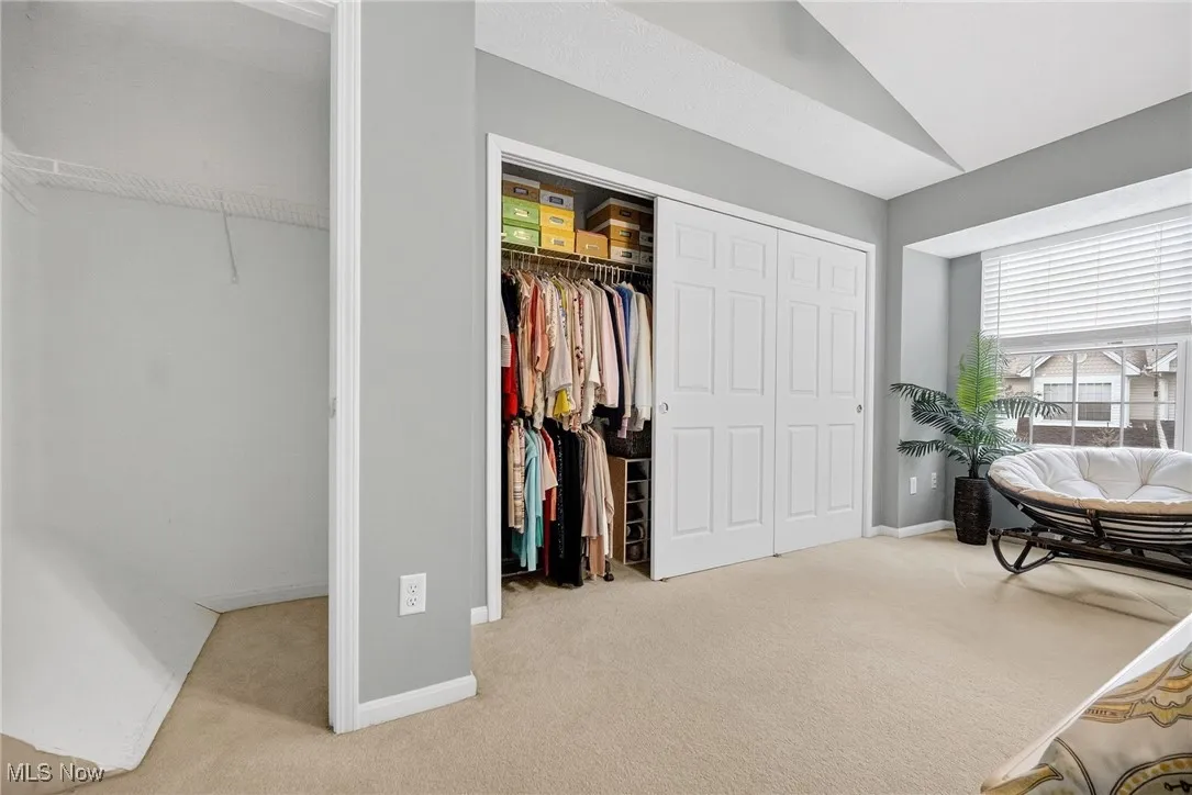 Bedroom featuring light colored carpet and lofted ceiling