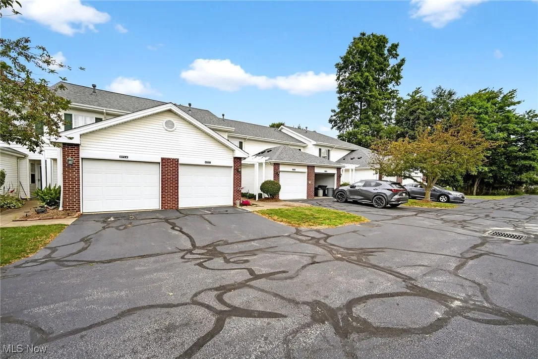 View of front of property with driveway and brick siding