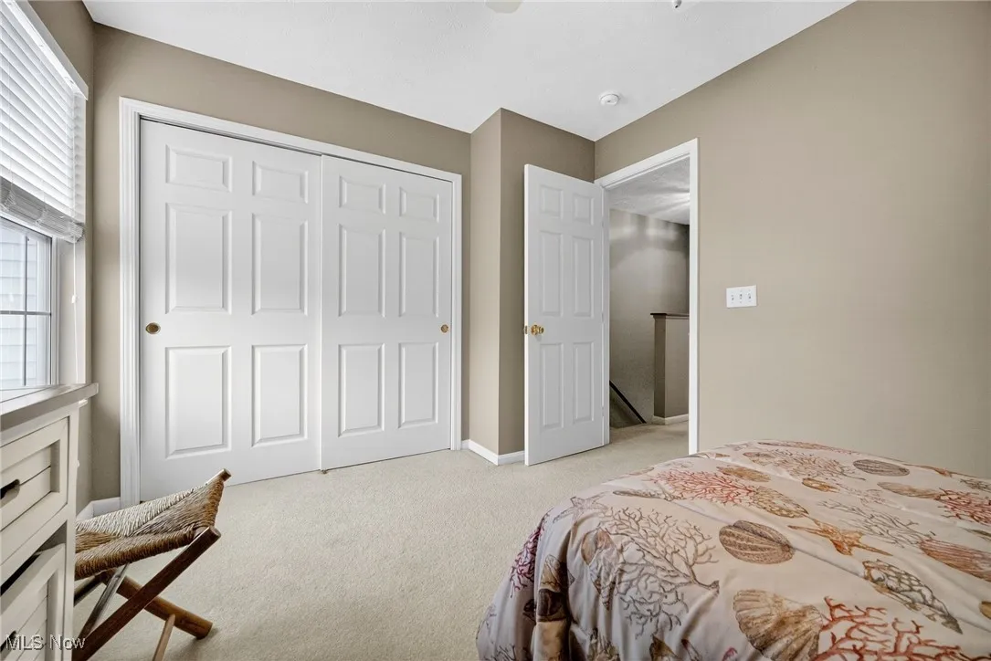 Bedroom featuring light colored carpet, a closet, and a ceiling fan