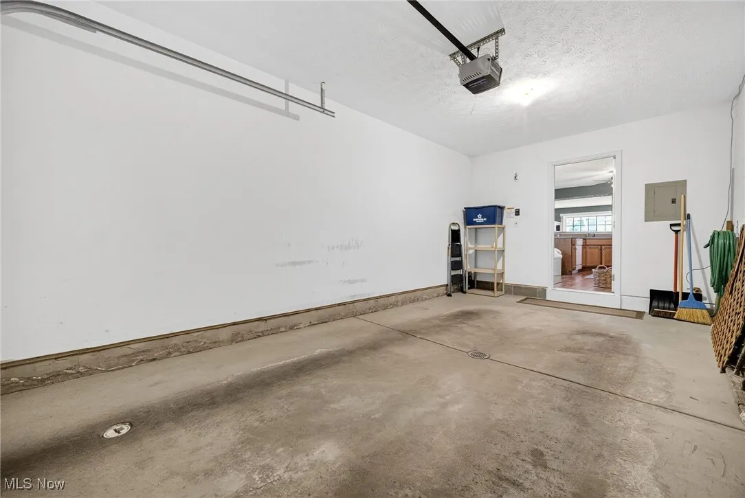 Garage featuring electric panel and a garage door opener
