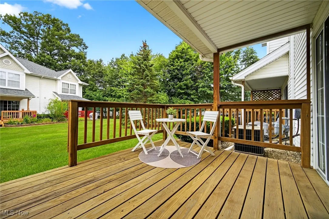 Wooden terrace with a yard and view of wooded area