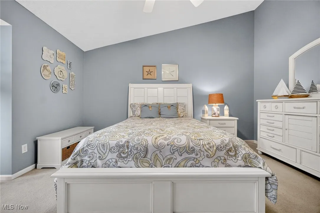 Bedroom with light carpet, lofted ceiling, and ceiling fan