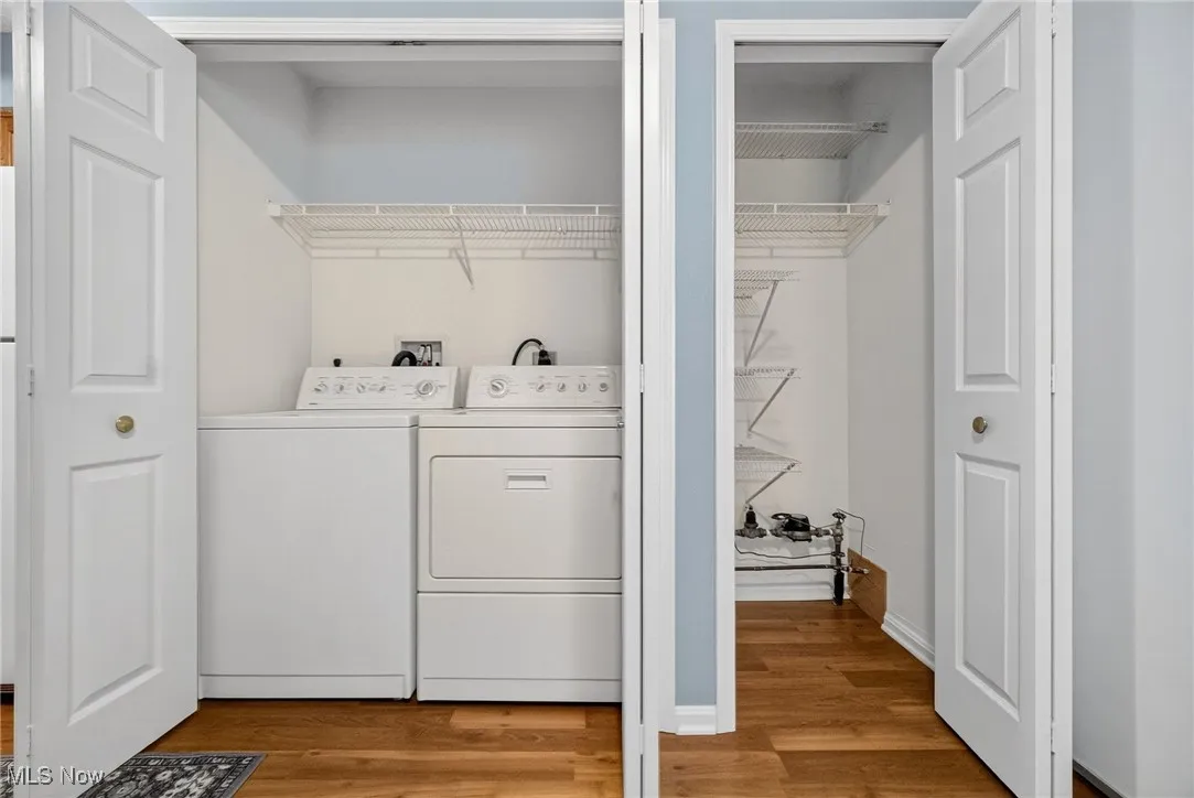 Washroom with light wood-style floors and separate washer and dryer