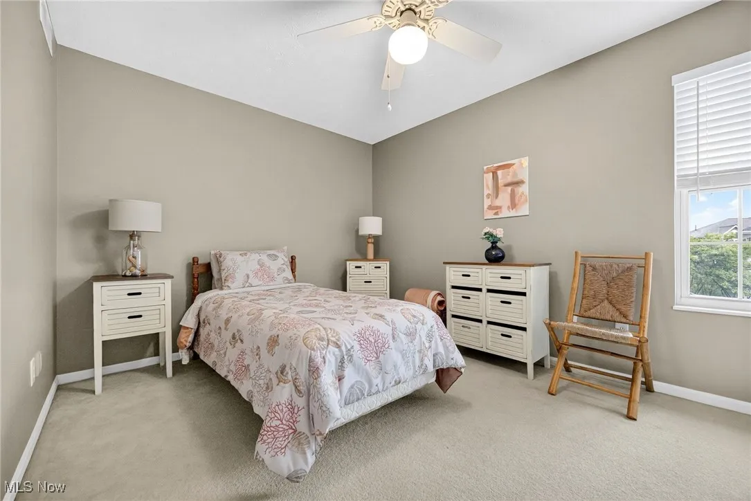 Bedroom with light colored carpet and a ceiling fan