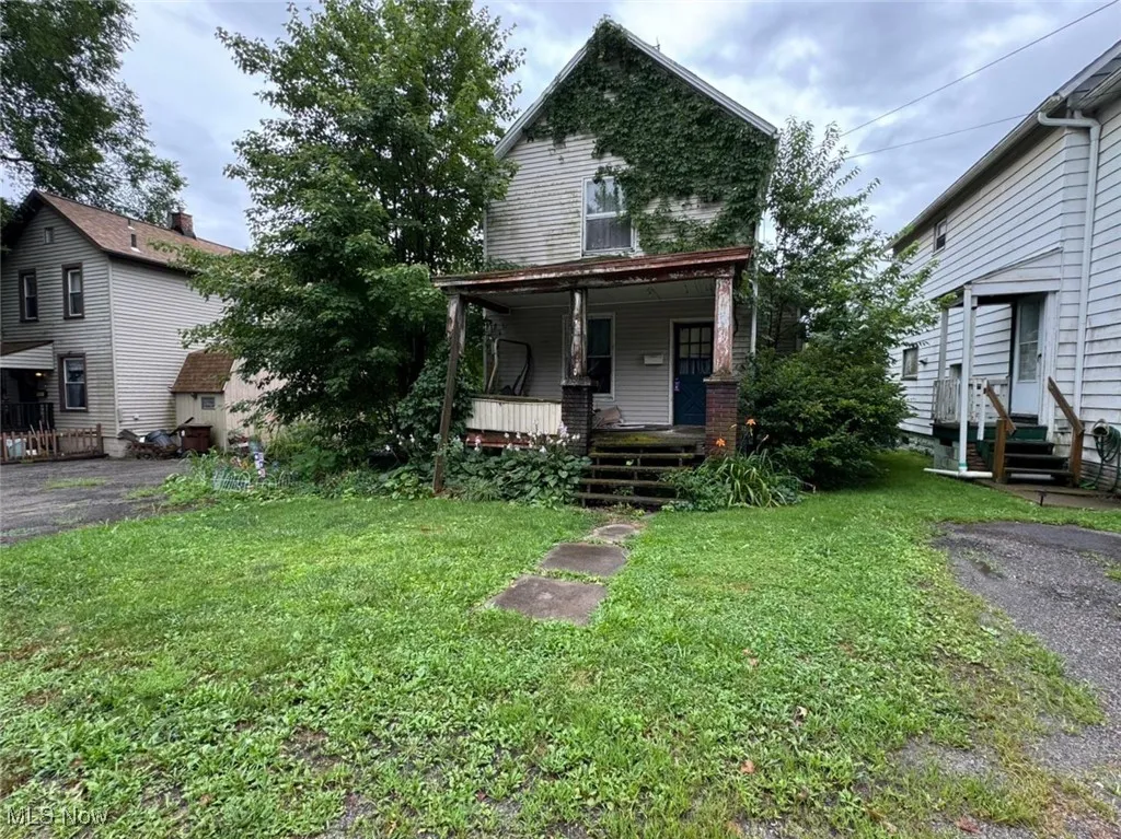 View of front of house featuring a front lawn and covered porch