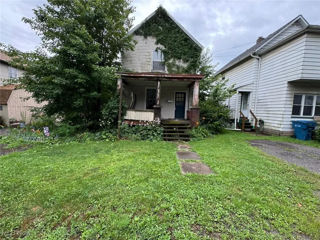 View of front of home with covered porch and a front lawn