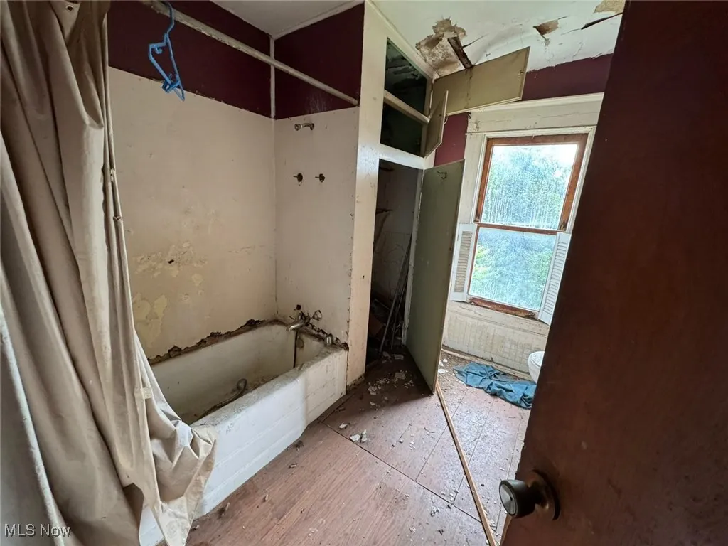 Full bath featuring toilet and shower / bath combination with curtain