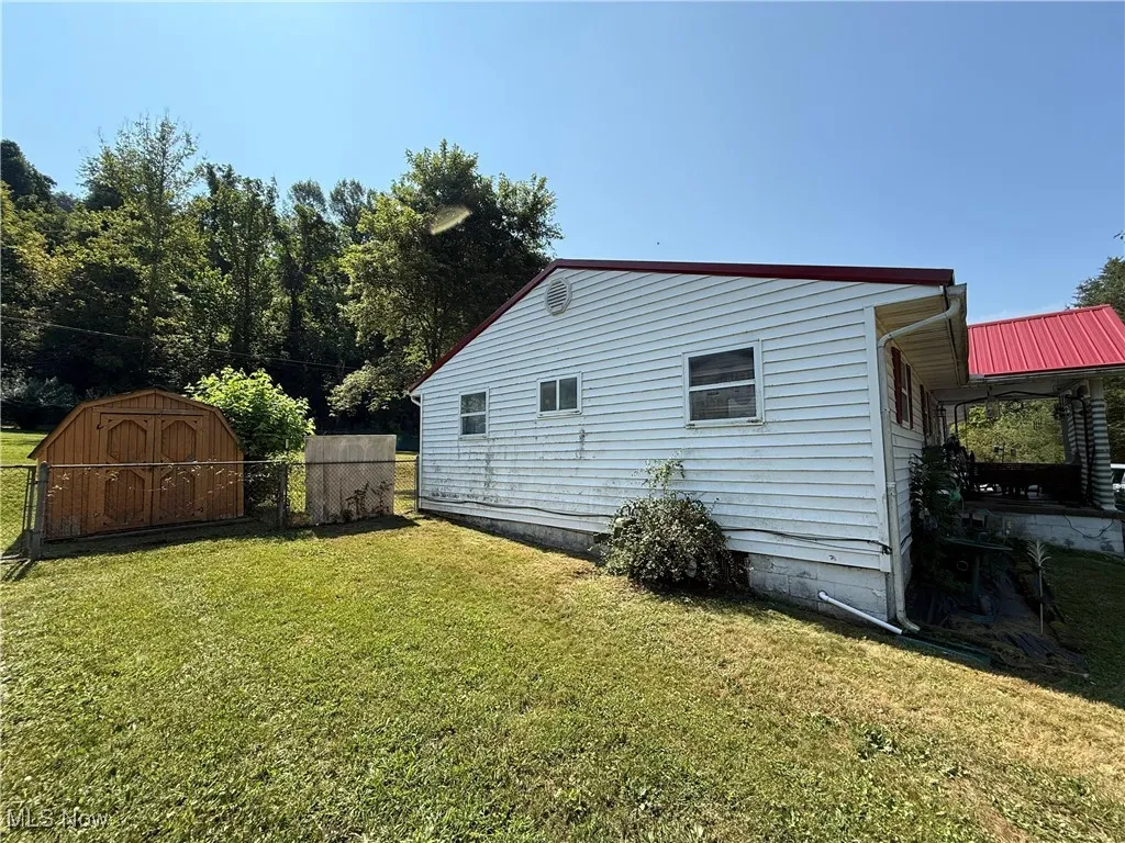 View of property exterior featuring a shed