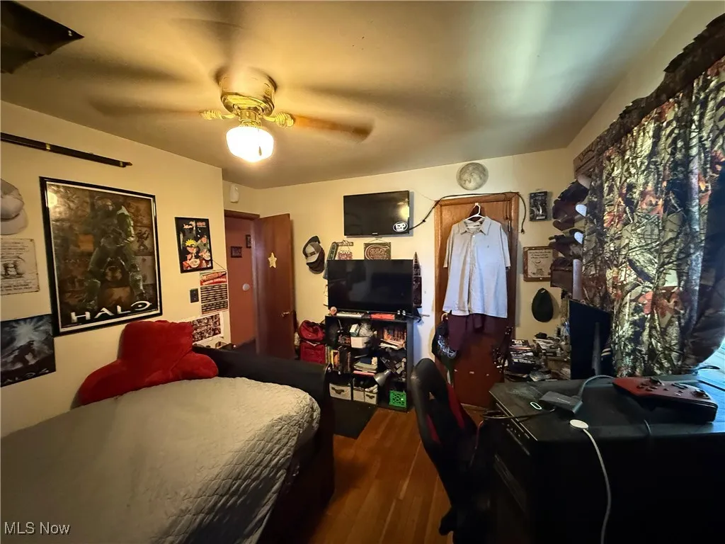 Bedroom with dark wood finished floors and a ceiling fan