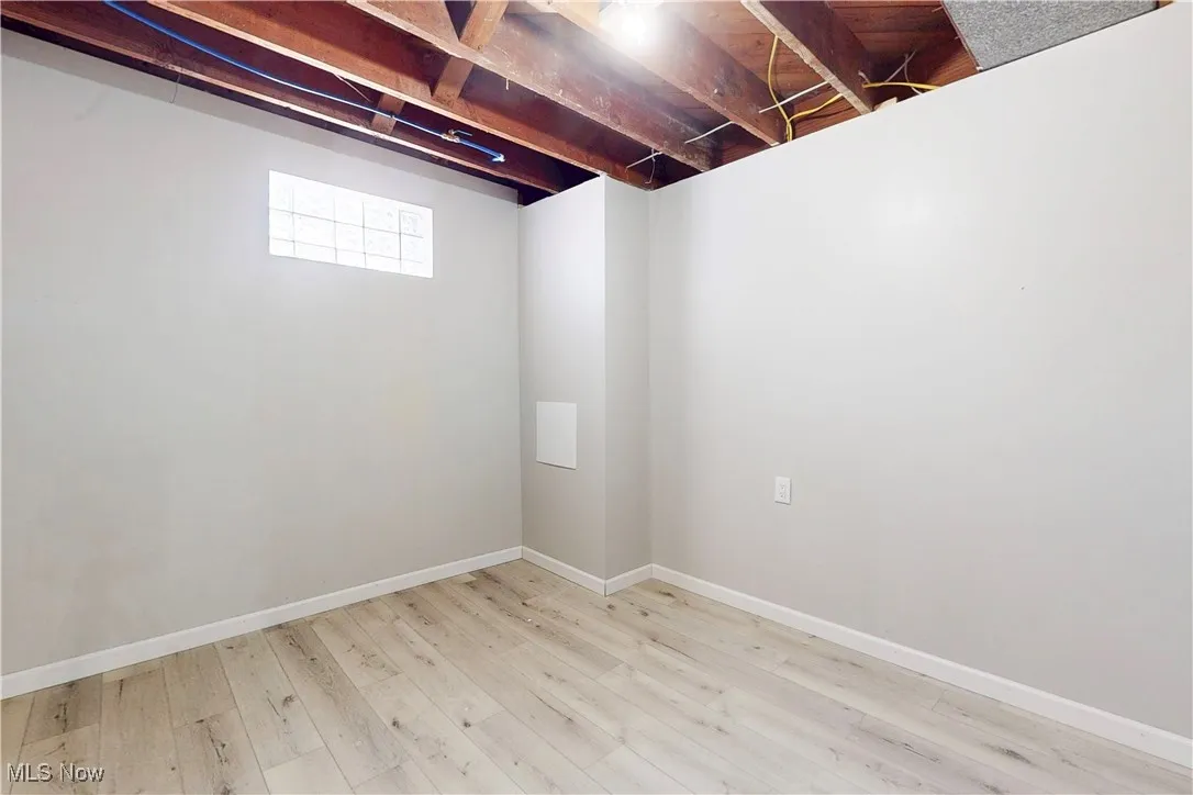 Basement featuring light wood-type flooring and baseboards