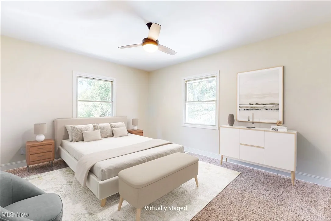Bedroom with multiple windows, light carpet, and a ceiling fan