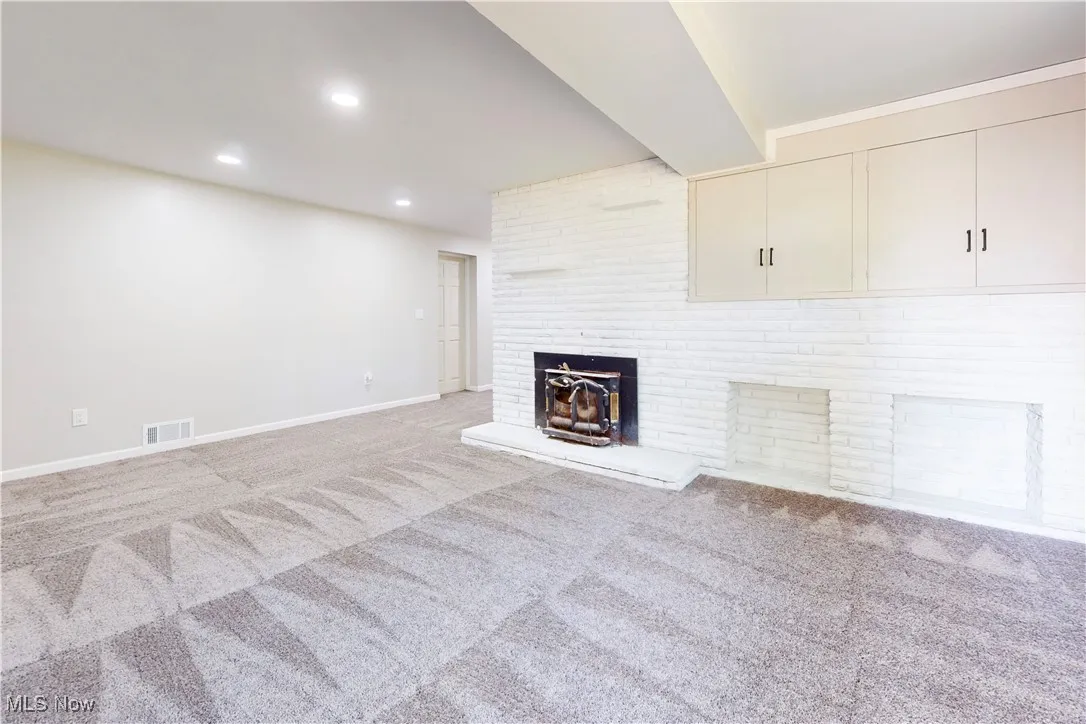 Unfurnished living room with carpet flooring, a fireplace, and recessed lighting