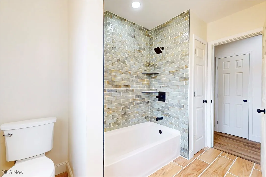 Full bathroom featuring shower / bath combination and wood tiled floors