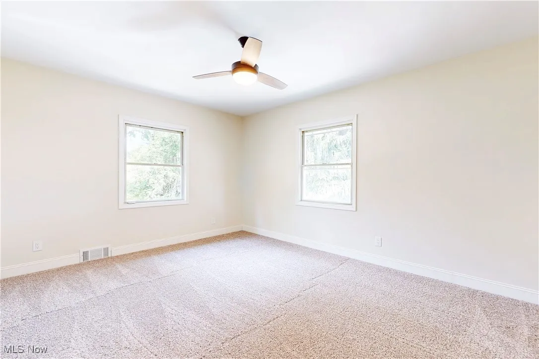 Empty room featuring light carpet and baseboards
