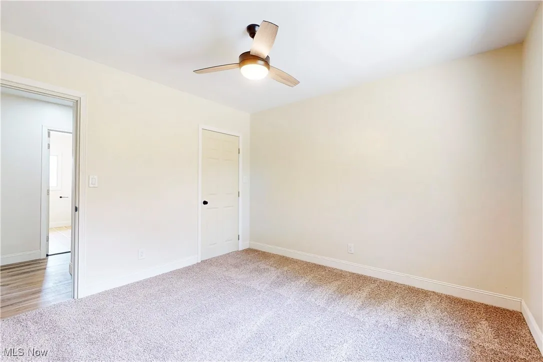 Spare room with light colored carpet and a ceiling fan