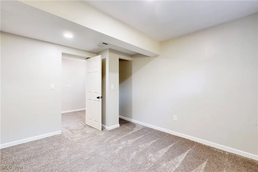 Finished basement with baseboards and light carpet