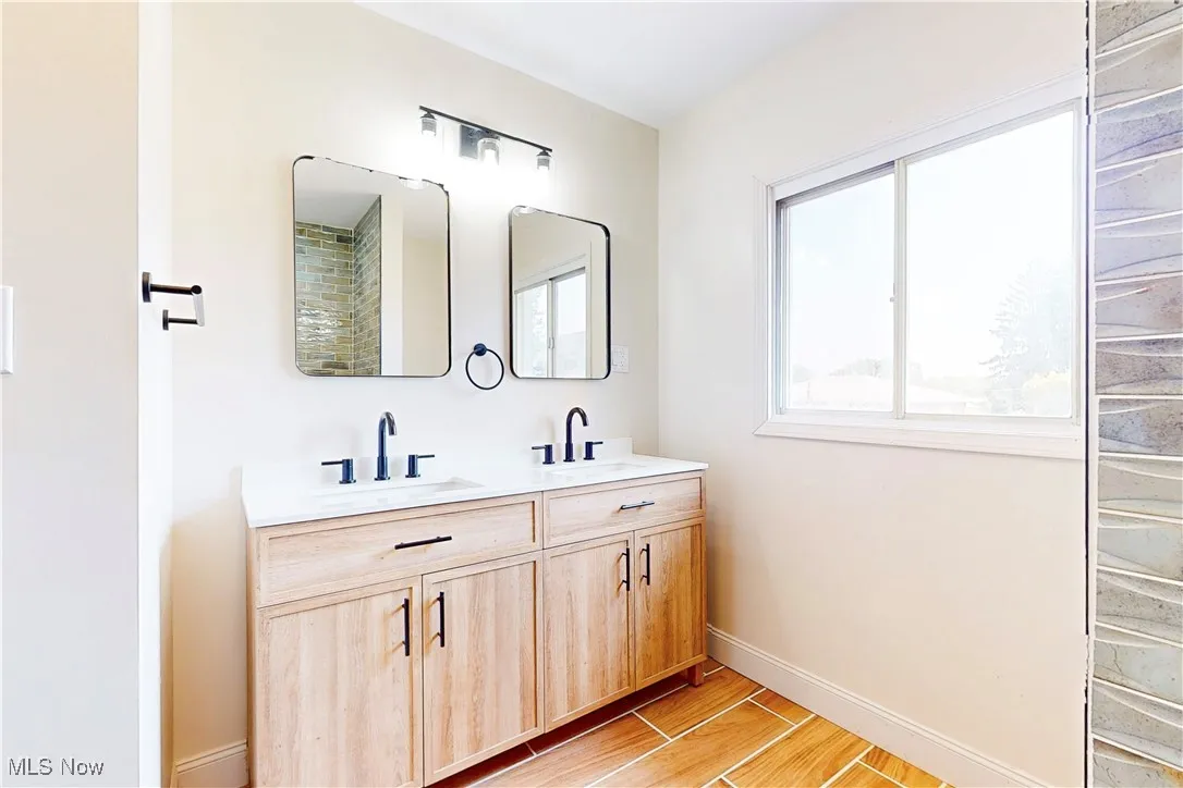 Bathroom featuring wood finish floors and double vanity
