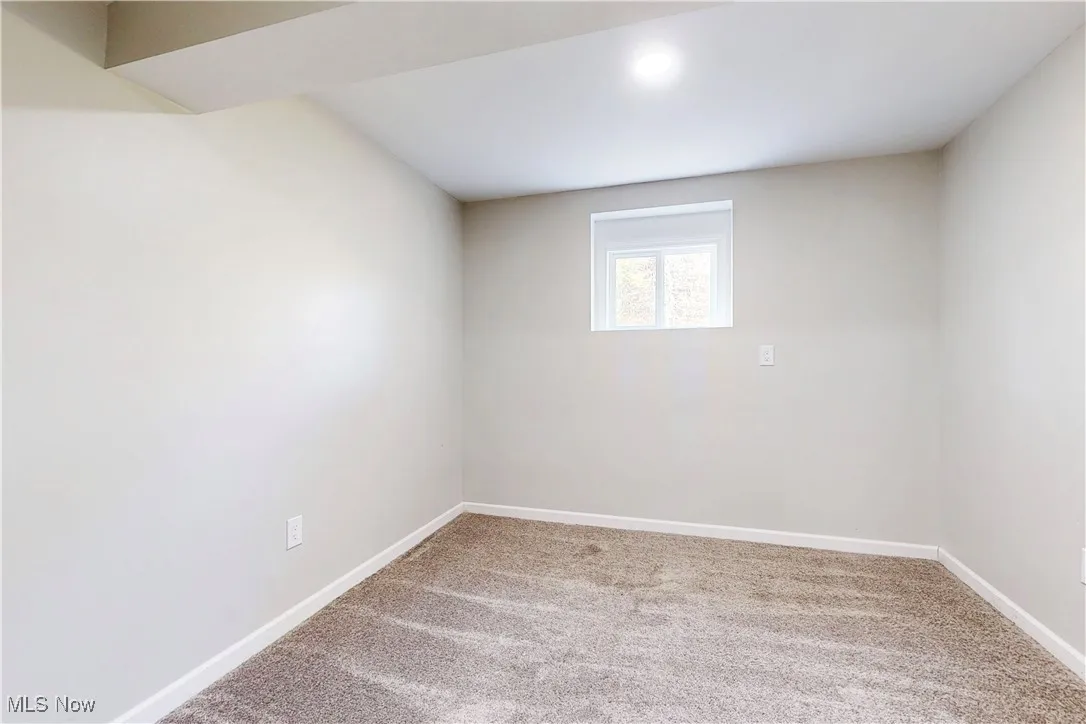 Unfurnished room featuring light colored carpet and baseboards