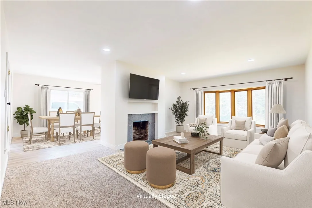 Living room featuring a tile fireplace, recessed lighting, carpet, and wood finished floors