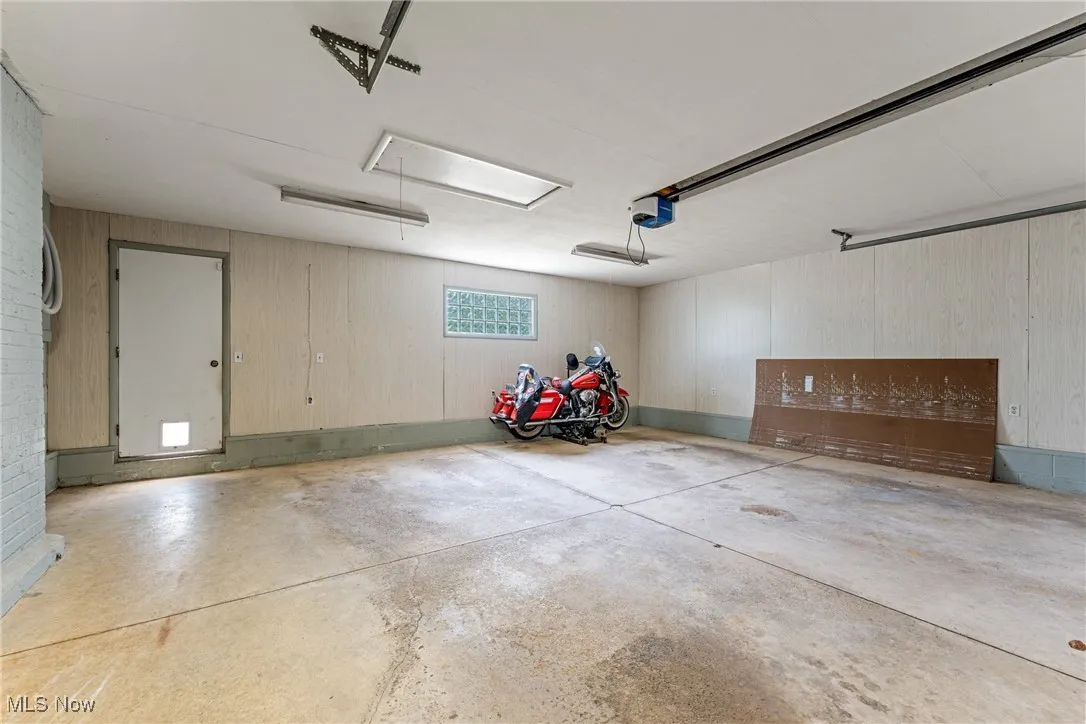 attached Garage with wood walls and a garage door opener