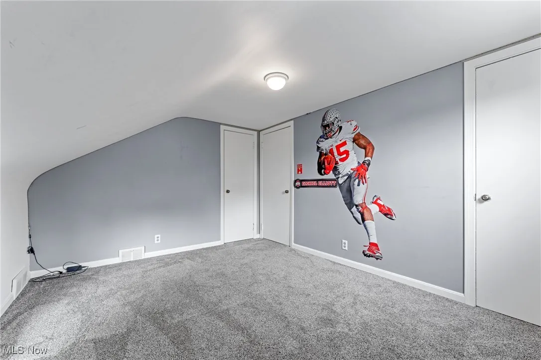 Bedroom 4 with carpet floors and vaulted ceiling