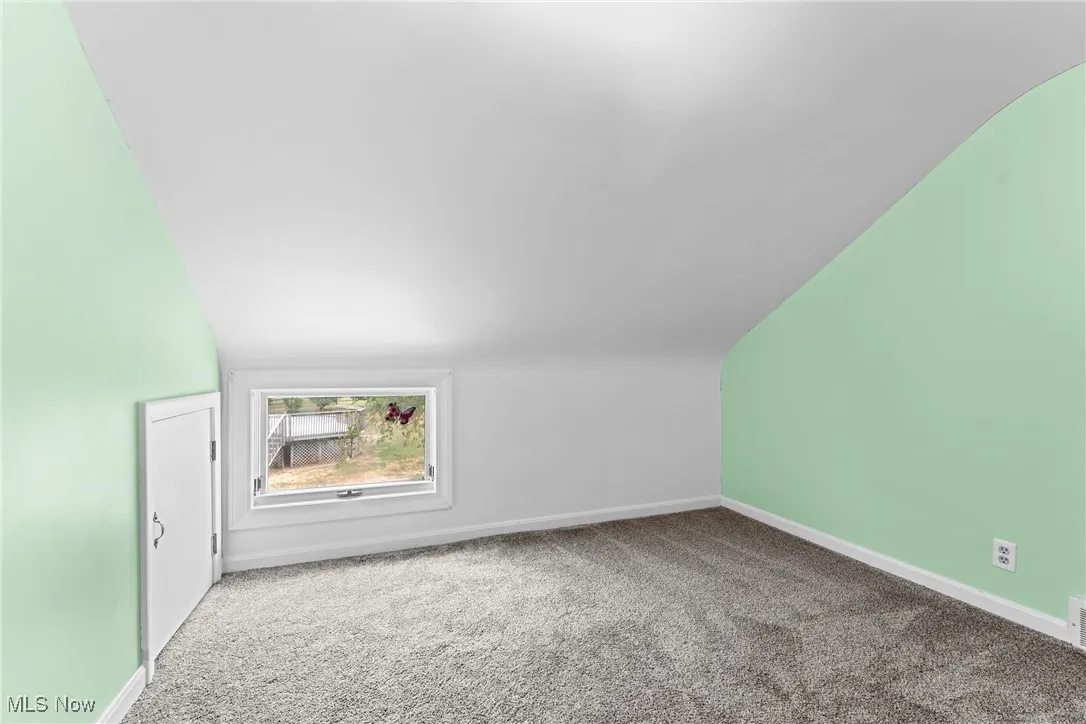 Bedroom 2 featuring carpet flooring and vaulted ceiling